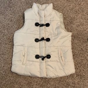White puffer vest: Zip and Horn toggle closures